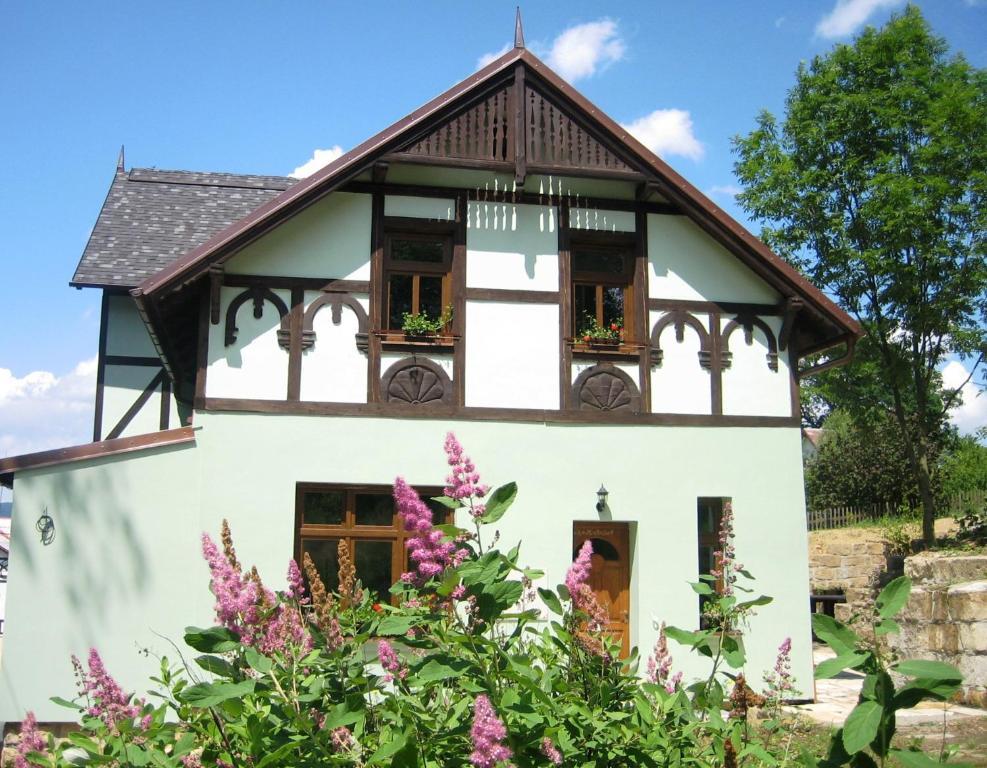 a white house with flowers in front of it at Penzion Arosa in Růžová