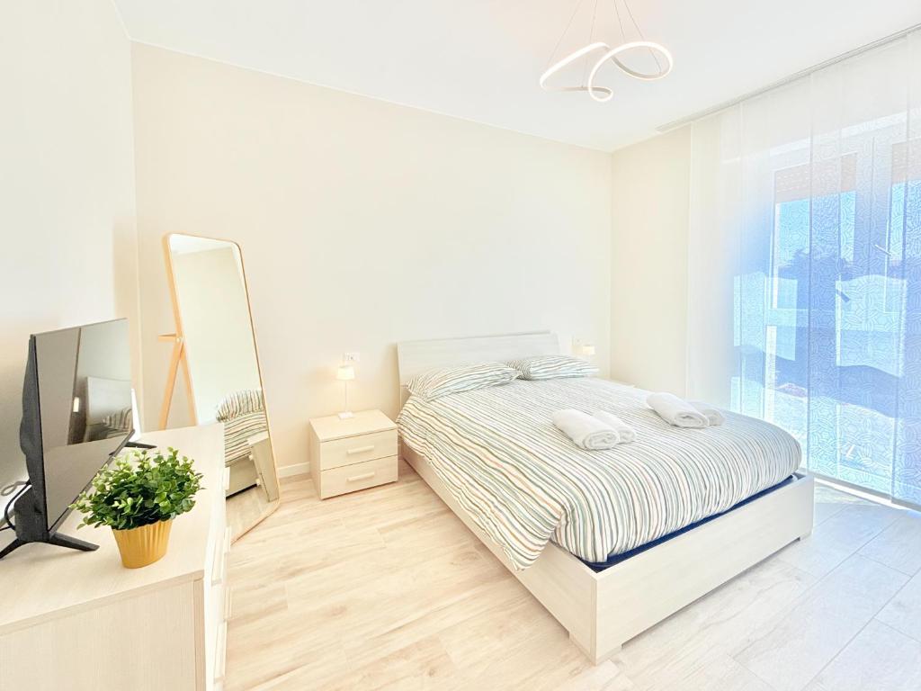 a white bedroom with a bed and a mirror at Milano Suite Francine in Milan