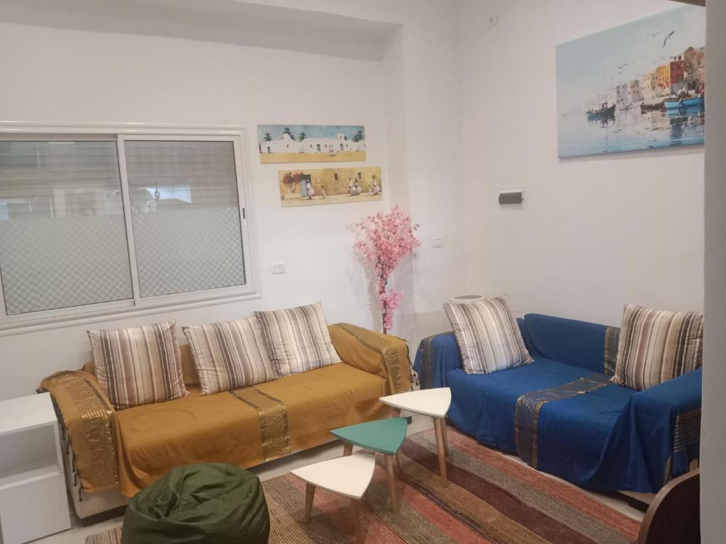 a living room with a couch and two chairs at Front beach cosy apartment in La Goulette