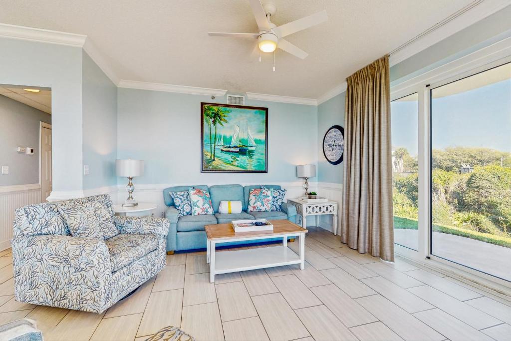 a living room with a couch and a table at Conveniently located Gulf condo with spacious layout pool & pickleball in Seacrest
