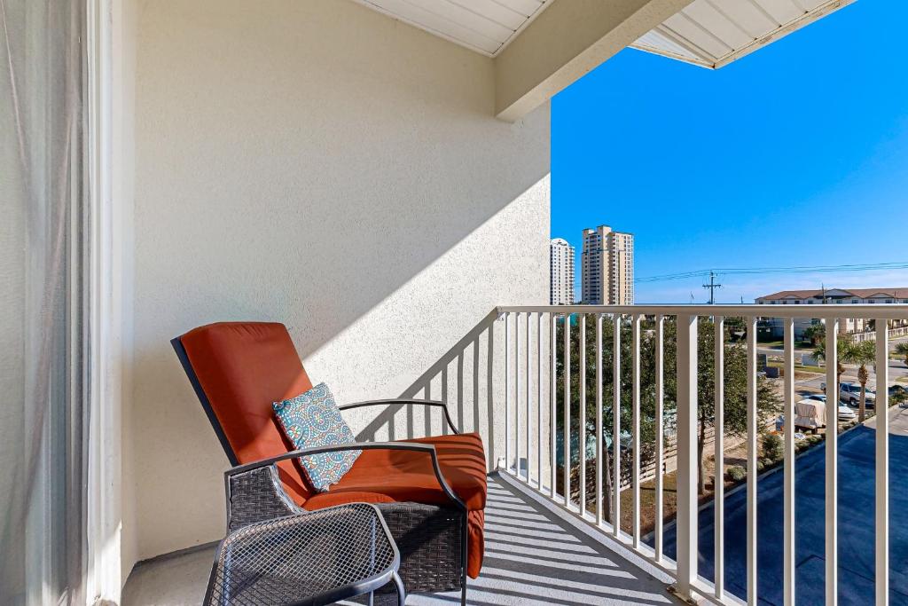 a balcony with an orange chair on a balcony at Spacious Condo with Balcony in Navarre Beach with Shared Pool in Navarre