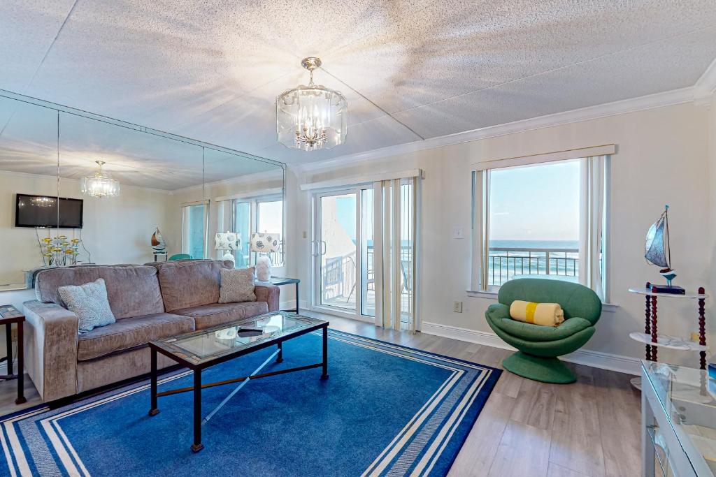 a living room with a couch and a table at Spacious 3rd-floor beachfront condo with stunning views pool pickleball & AC in Fort Walton Beach