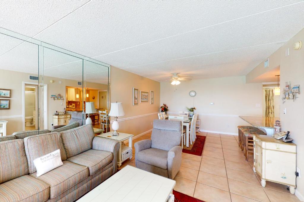 a living room with a couch and a table at Comfortable 6th-floor beachfront condo with ocean views - walkable locale in Fort Walton Beach