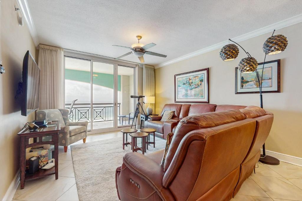a living room with a couch and a table at Roomy beachfront condo with full kitchen shared pool and beach access in Fort Walton Beach