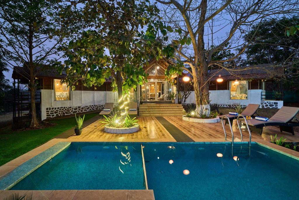 a house with a swimming pool in the yard at SaffronStays Anjee's Chalet in Dhamni