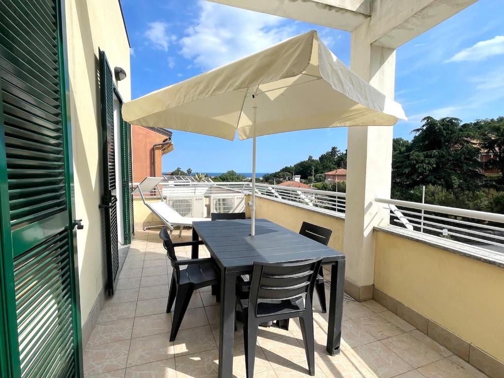 a table and chairs on a balcony with an umbrella at Relax Ligure in Boissano