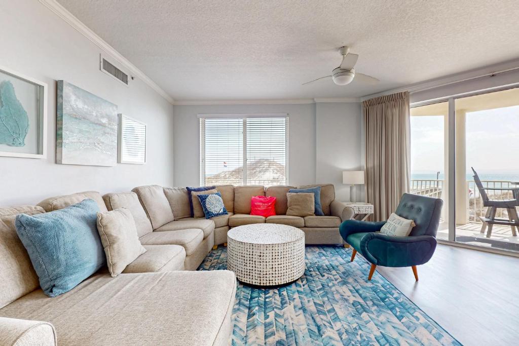 a living room with a couch and a table at Ground floor beachfront condo with shared pool and beach access in Santa Rosa Beach