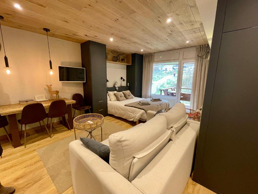 a living room with a couch and a bed and a table at Apartaran 407 con terraza in Betrén