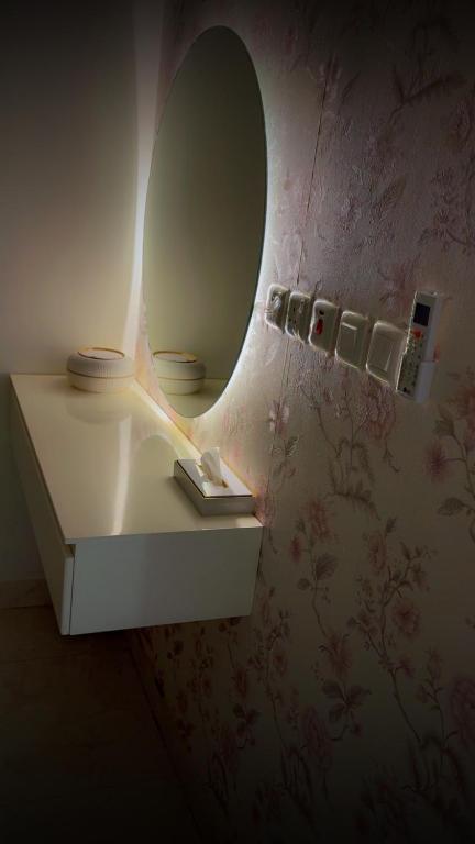 a bathroom with a mirror and a shelf with a book at ستارز هاوس in Najran