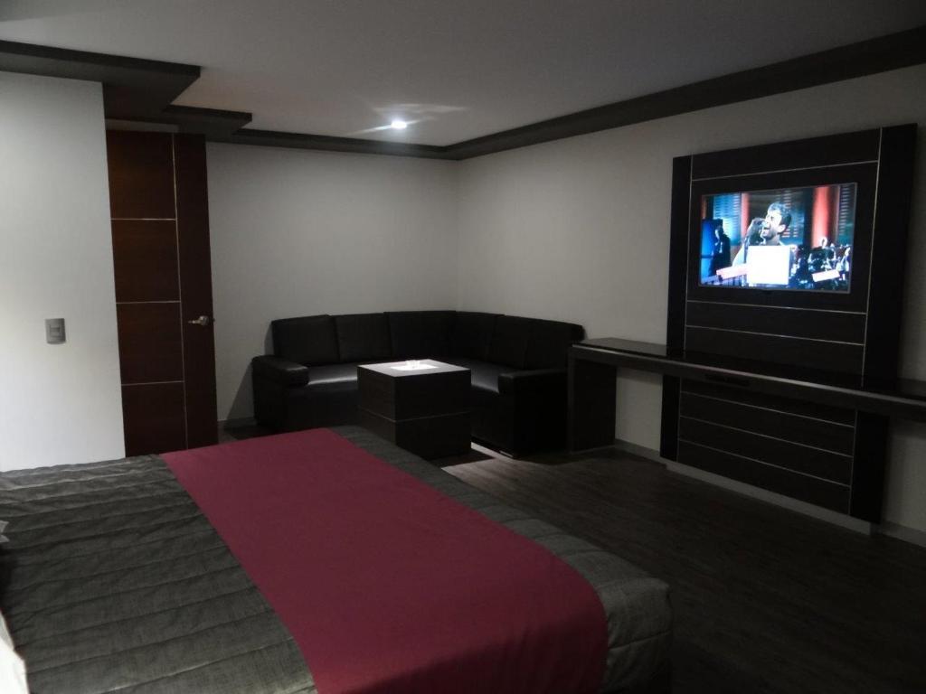 a bedroom with a bed and a flat screen tv at H Boutique Touca in Toluca