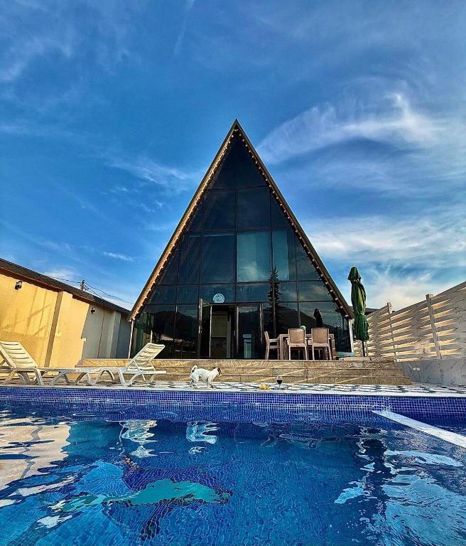 a house with a pyramid shaped building with a swimming pool at Luxury A-Frame Forest Chalet in Gabala