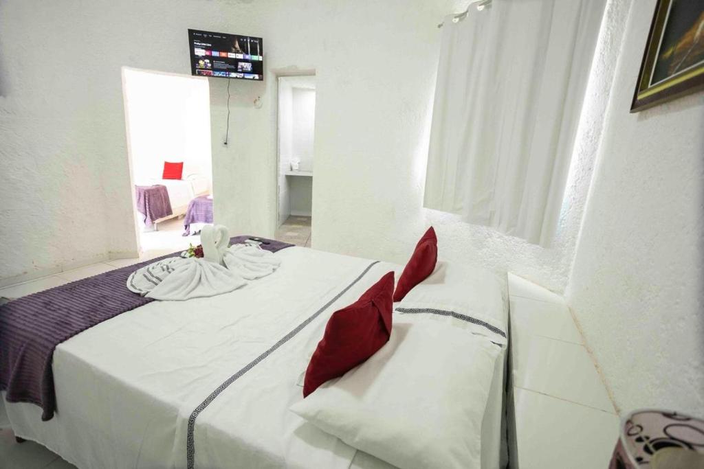 a bedroom with a bed with red pillows on it at Pousada Marajoara- Hotel Fazenda-Turismo de Aventura in Soure