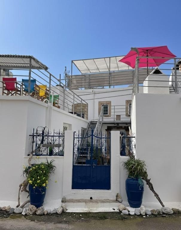 a white house with a blue door and a red umbrella at Heritage House Malonas in Malona Village