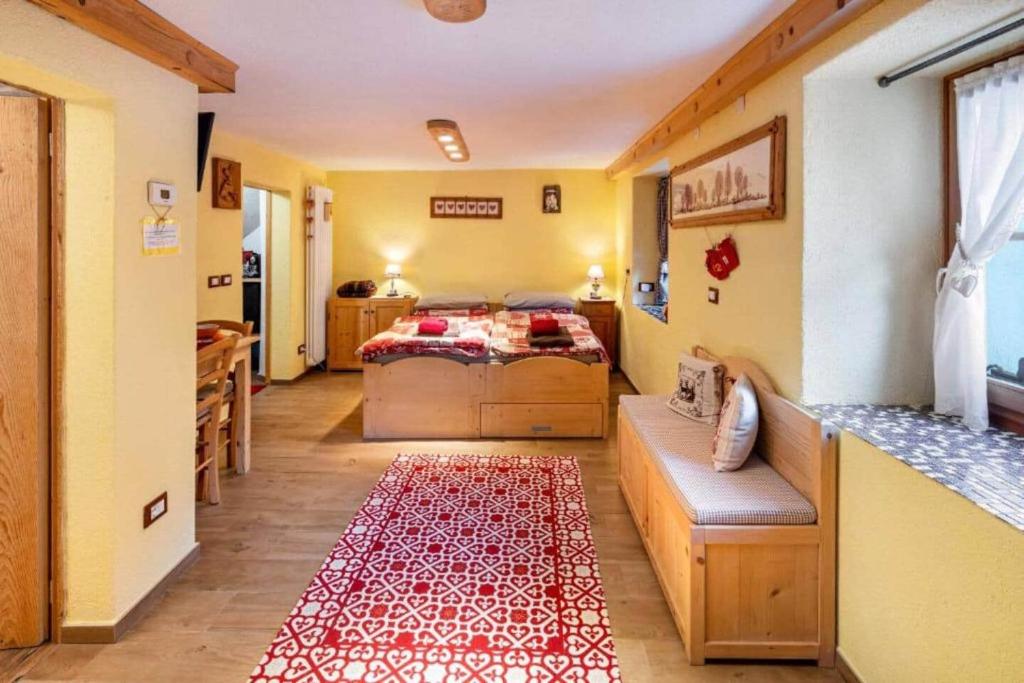 a bedroom with a bed and a red rug at Ciesa del Selmo Faure in Sottoguda