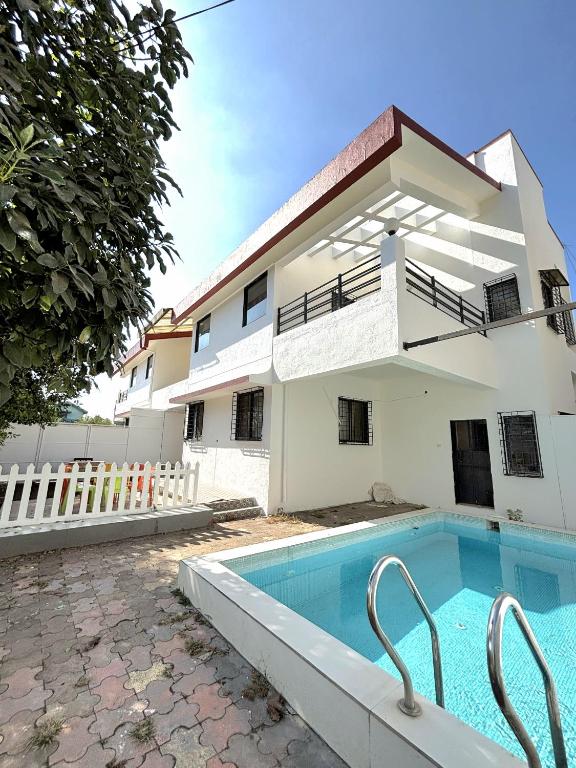 a villa with a swimming pool in front of a building at ll MOCKTAIL VILLA ll 3BHK ll AC ll PRIVATE POOL ll MALAVALI ll in Lonavala