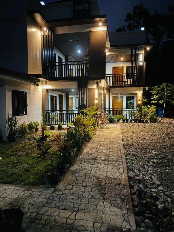 a building with a stone walkway in front of it at Tiwi's Travellers Inn - Solar Powered, Starlink, Scooter Rental, Palawan Tours in Puerto Princesa City