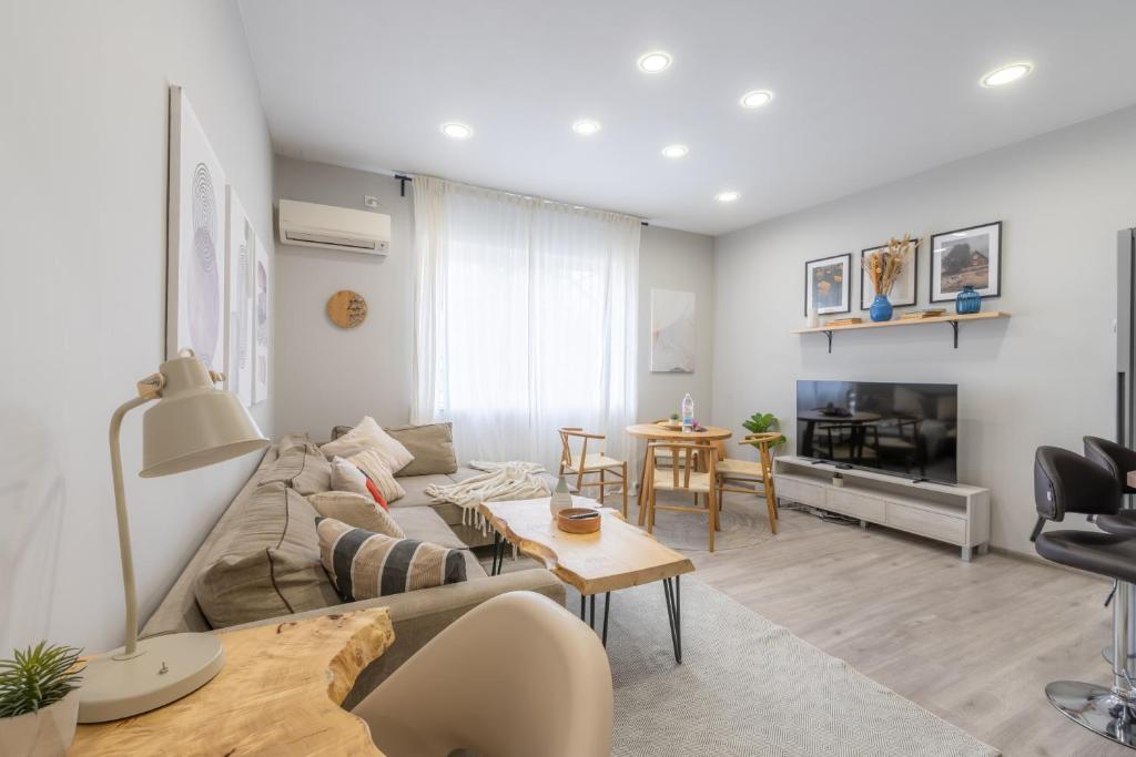 a living room with a couch and a table at NDK - UrbanLux Medius 2BDR FREE Parking in Sofia