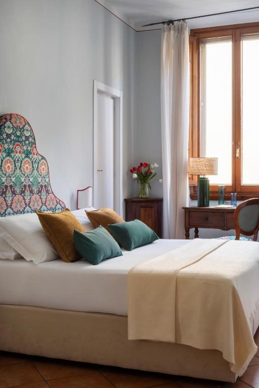 a bedroom with a large white bed with pillows at Hotel Galileo in Florence
