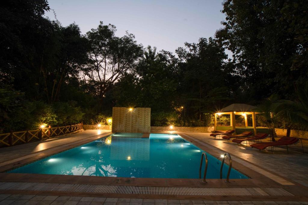 a swimming pool at night with a gazebo at Treebo Premium Mowgli's Den, Pench Tiger Reserve, Turia in Khawāsa
