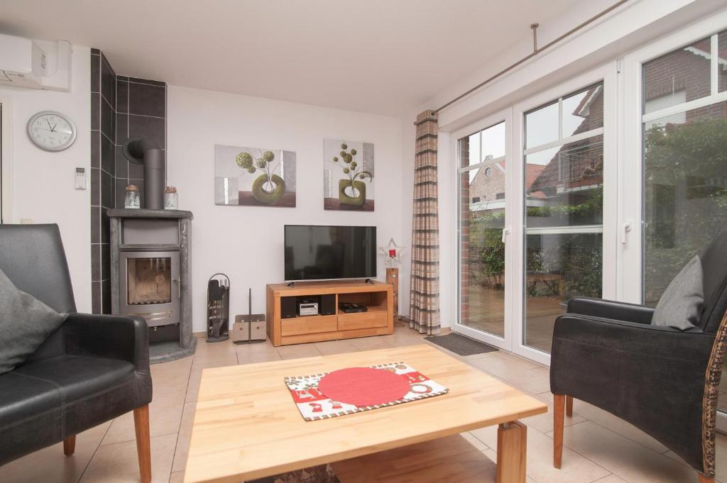 a living room with a tv and a table at Ferienhaus Carpe Diem in Greetsiel