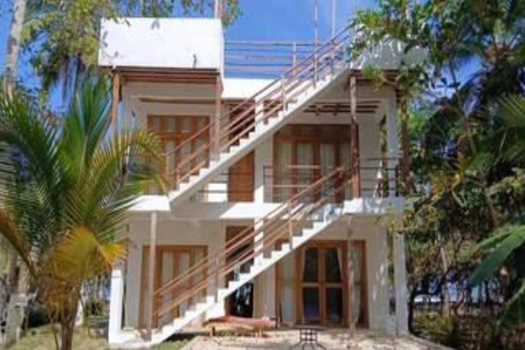 a white building with stairs on the side of it at Playa Mulata in Moñitos