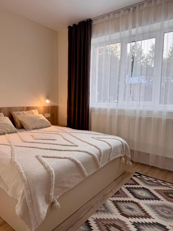 a bedroom with a bed and a large window at Рандеву in Slavske