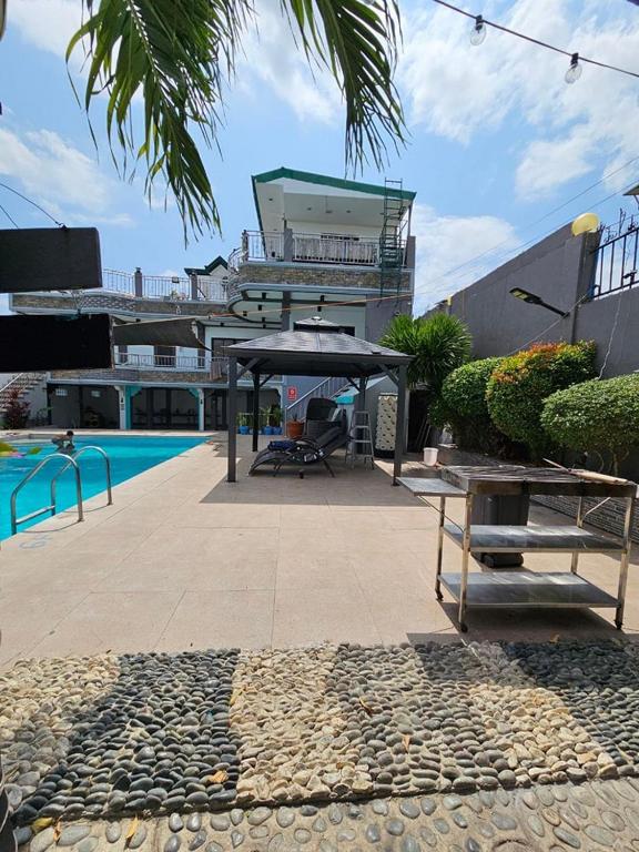a building with a swimming pool and a patio at Crestscente Skye Villa Resort in Pañgil