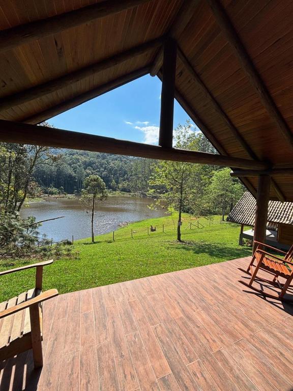 a porch with a view of a lake and a bench at refugio in Aguas Mornas