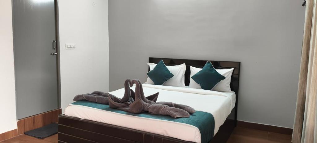 a bed with two pairs of shoes sitting on it at Elevate 1478 Inn in Nandigunda