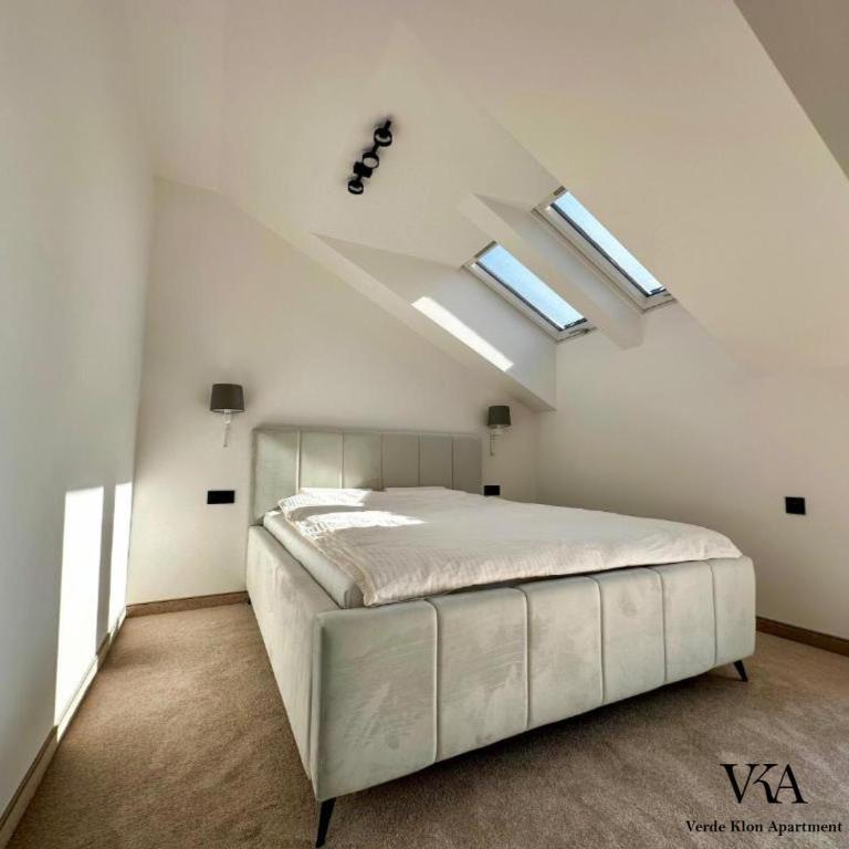 a bedroom with a large white bed with skylights at Verde Klon Apartment- Lotnisko Jasionka in Jasionka