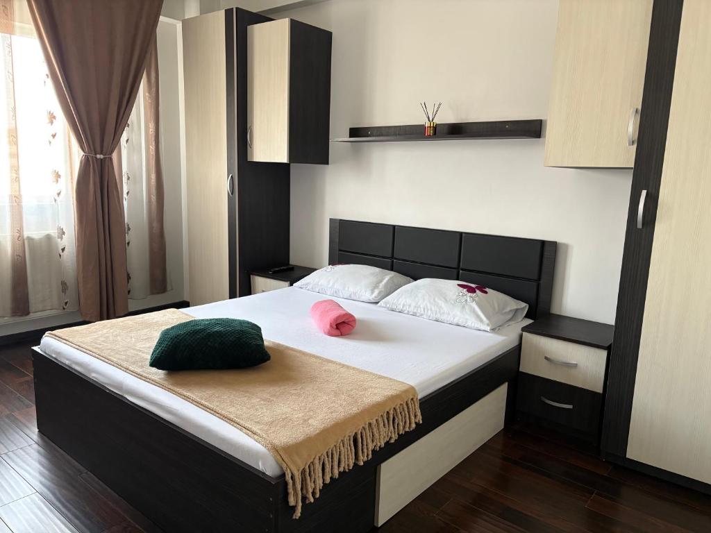 a bedroom with a bed with a pink hat on it at Bella Home Residence2 in Roşu