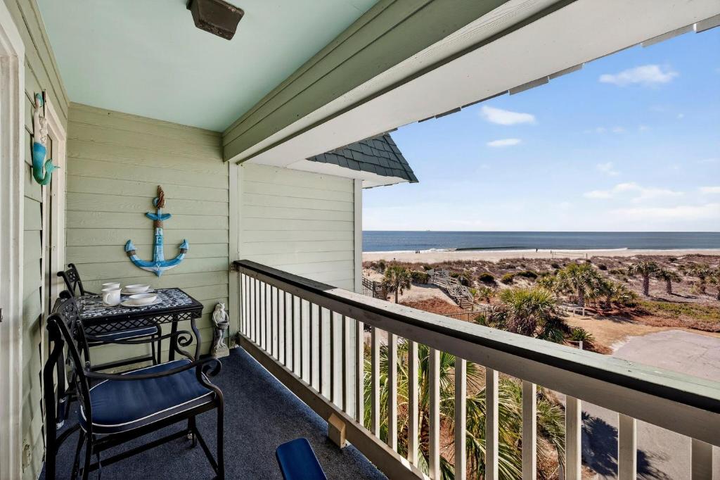 a balcony with a table and a view of the beach at SC304A: 304A Sea Cabin in Isle of Palms
