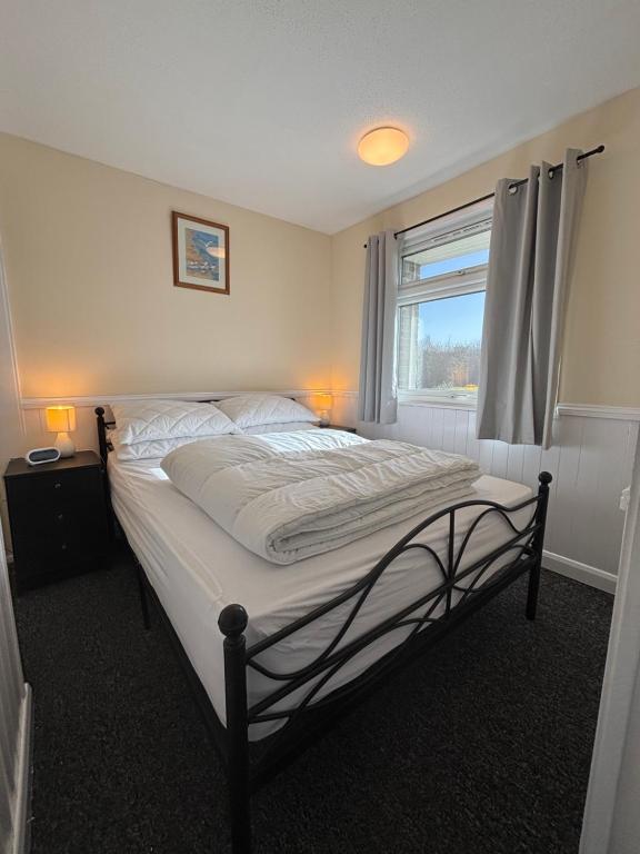 a large bed in a bedroom with a window at 116, Two bed Chalet on California Sands Holiday Park - Sleeps 5, pet friendly, includes FREE pool passes, Free Entry to Clubhouse - plus Electric, WiFi, bed linen and towels all included - only 300m from the beach! in Scratby