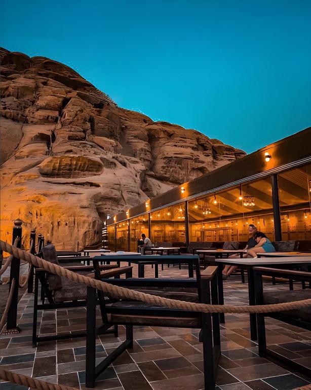 a building with tables and a rock wall at ULORA Luxury Camp in Wadi Rum
