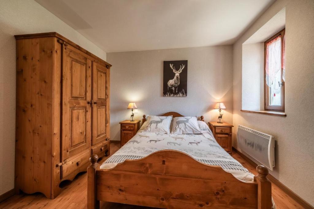 a bedroom with a wooden bed and a wooden cabinet at La Ferme de Sous-Lachat in Samoëns