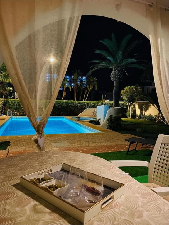 a tray of wine glasses on a table next to a pool at Luxuriöses Chalet mit privatem Pool in Roquetas de Mar