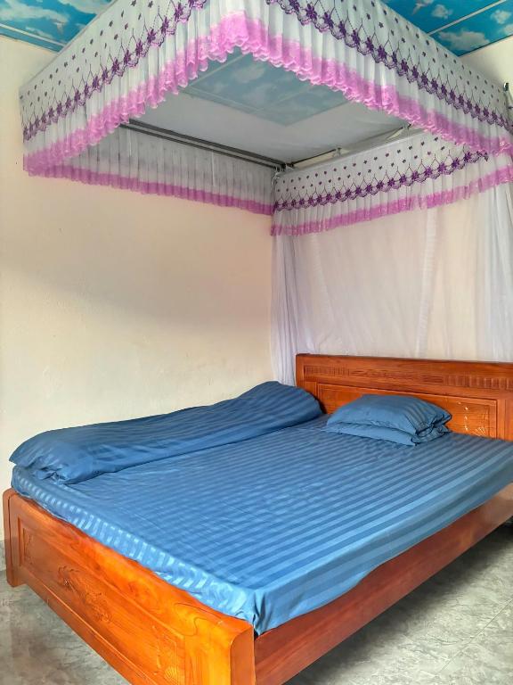 a bed with a wooden bed frame and a canopy at Homestay Mường Lay in Bản Pong