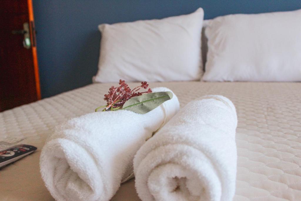 a pile of towels on top of a bed at Pousada Porto Maresias in Cabo Frio