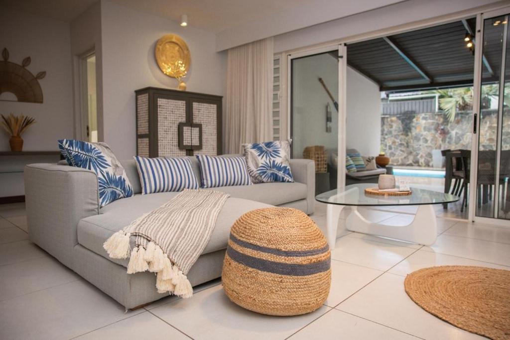 a living room with a couch and a table at Seascape Villa in Pointe aux Biches