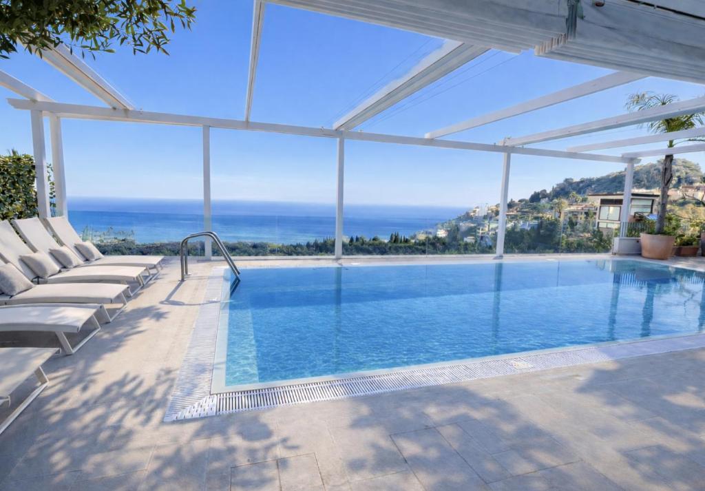 a swimming pool with a view of the ocean at MEDITERRANEAN SEASONS, VILLA MEDITERRANEA Taormina, Private Pool & Sea View in Taormina