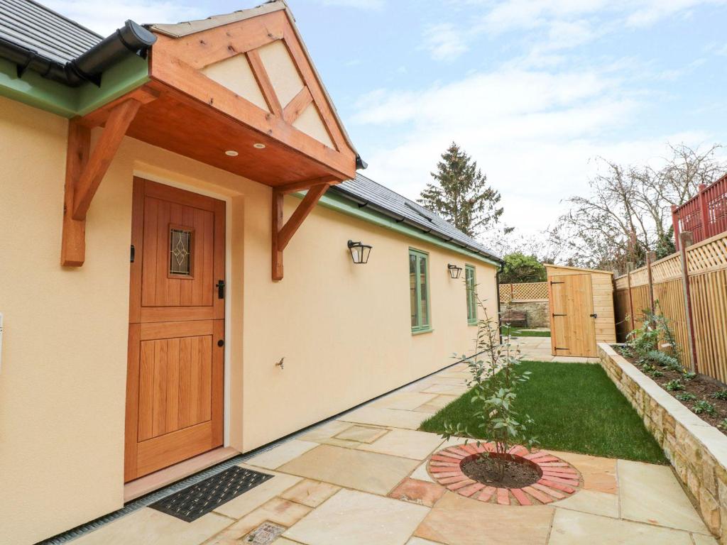 a house with a wooden door in a yard at Old Sorting Office in Cheltenham