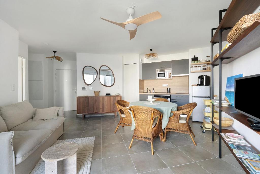 a living room with a table and chairs and a couch at Cocon Terrasse près du Port - A102 in Pornic