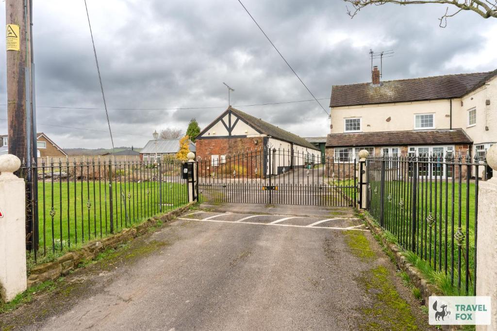 a gate in front of a house with houses at Birchenfield Holiday Cottages in Dilhorne