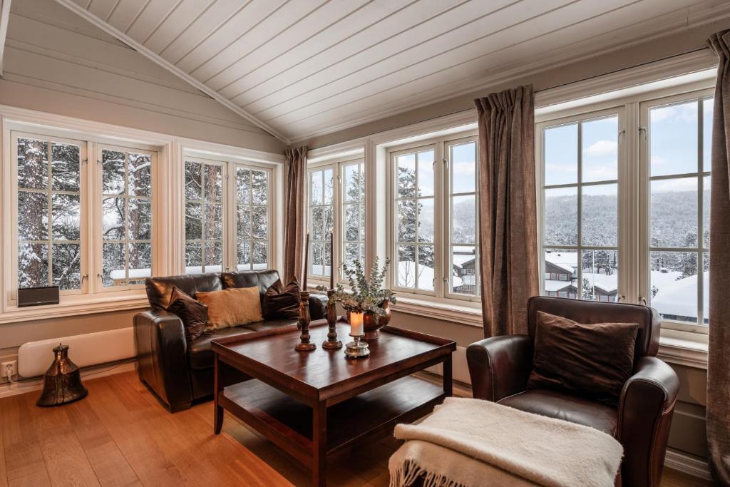 a living room with a couch and chairs and windows at Cosy and central Apartment in Holo