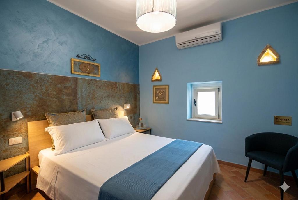 a bedroom with a large bed and a blue wall at Dimora Sogno Suite in Termoli