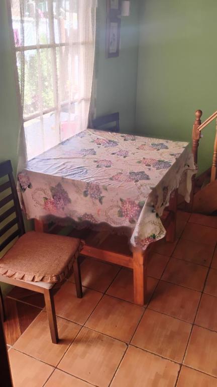 a table and a chair in a room at Cabaña La Perla in Isla Negra