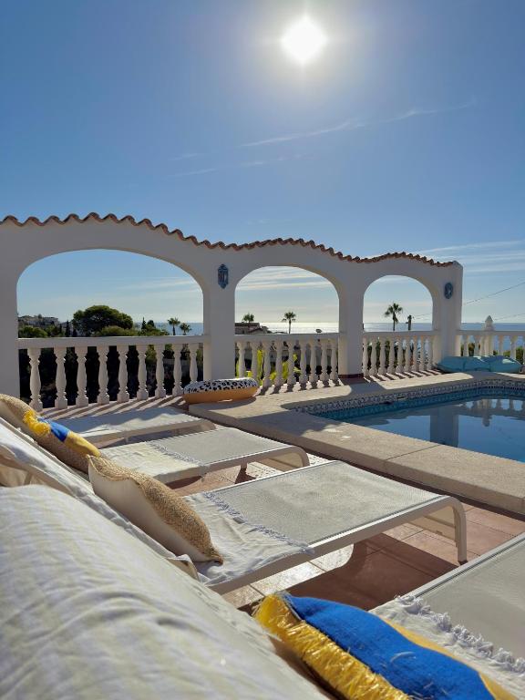 a resort with a swimming pool with lounge chairs and a swimming pool at Villa Cala Lanuza in Alicante