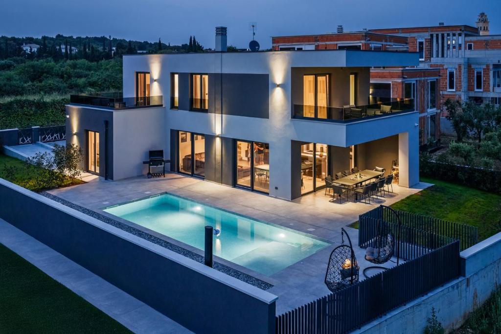 a house with a swimming pool in front of it at Villa Delecto in Premantura