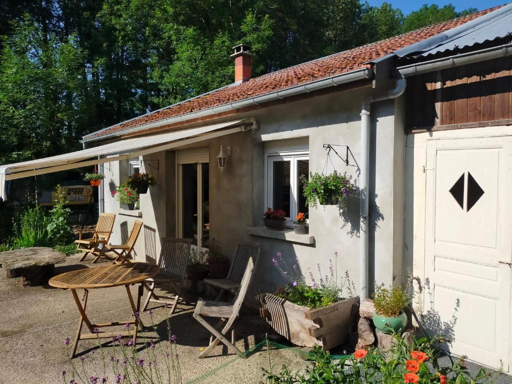 a cottage with a table and chairs in the yard at Logis51 in Ville-sur-Tourbe
