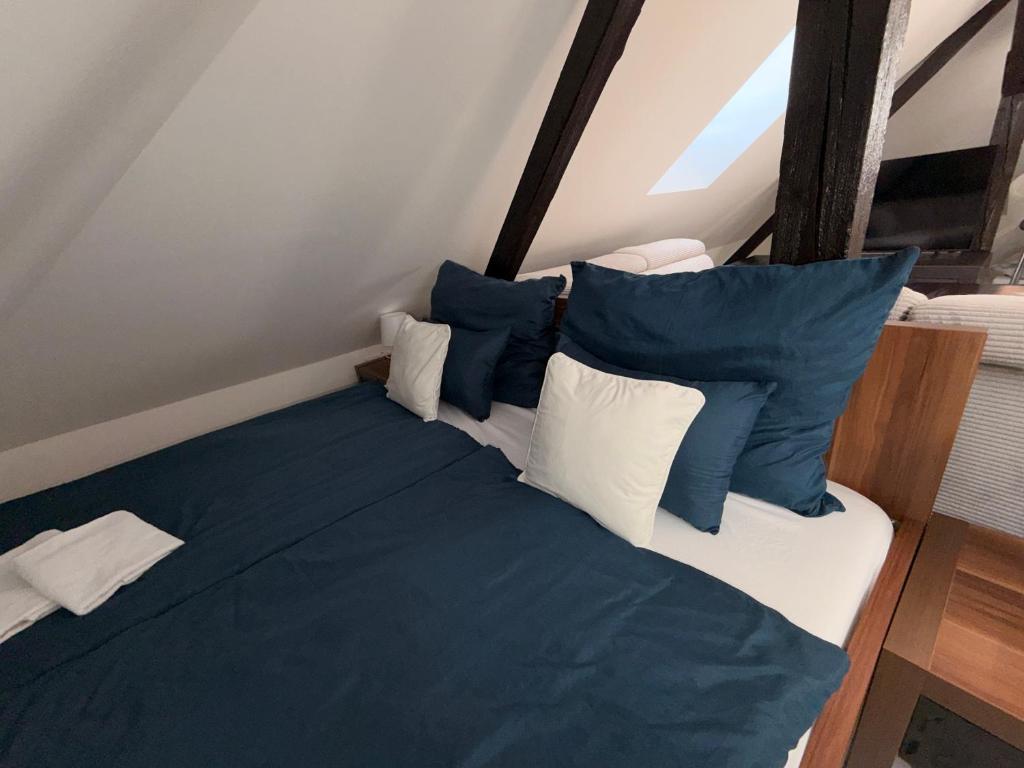 a bed with blue and white pillows in a room at Loft Apartment with Parking in Poruba
